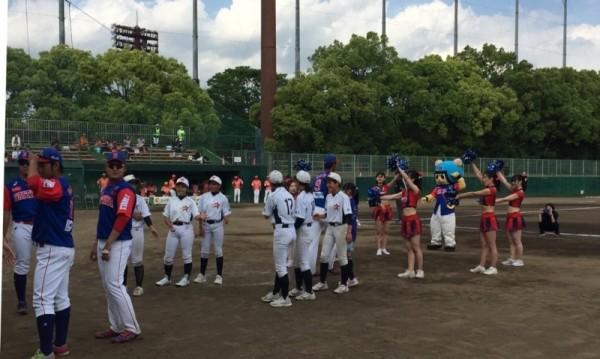 選手とチアガールとユニフォームを着た子供たちがグラウンドに集まっている写真