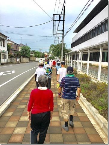 市役所前の歩道を2列になってウォーキングしている参加者達の写真