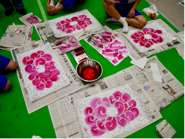 色付け作業がされた菊の花の絵が並べられている写真