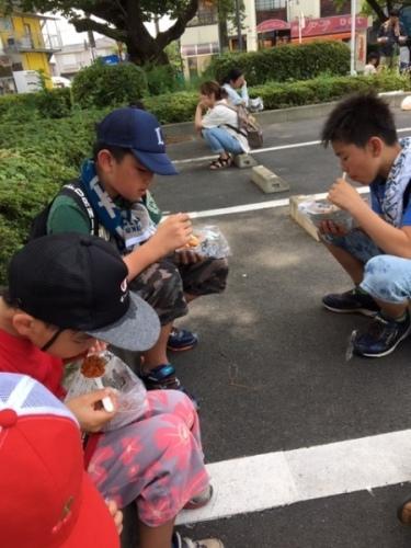 座って、カレーを食べている男の子3人の写真