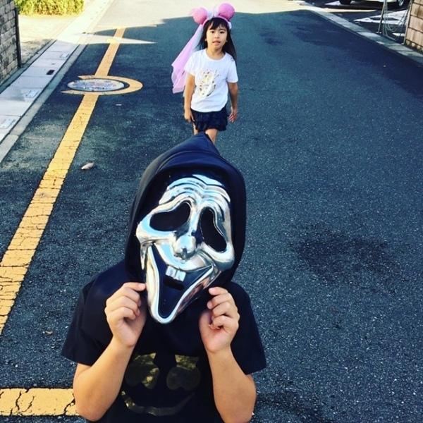 ピンクの丸い耳をつけた女の子と黒の骸骨のマスクをつけた男の子の写真