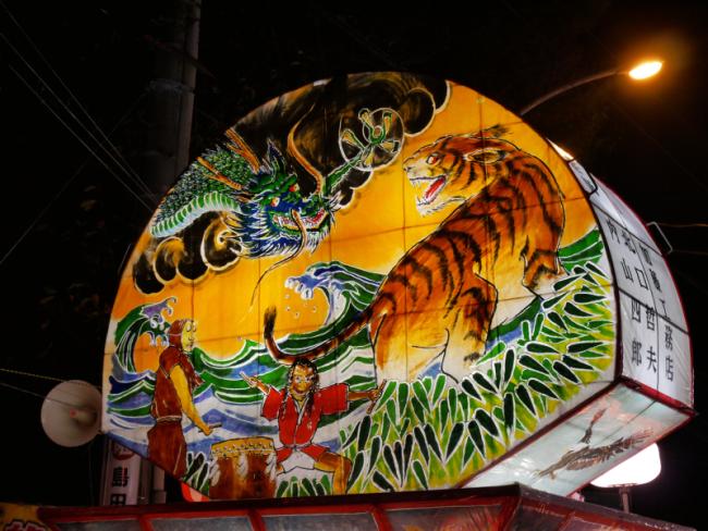 竜と虎がにらみ合っている絵が描かれたねぷたの写真