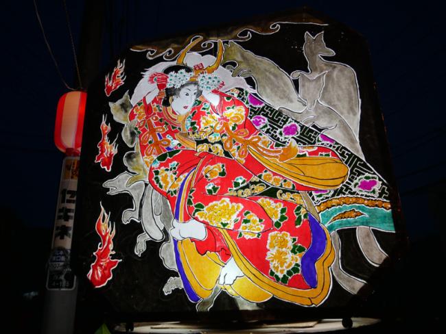 鮮やかな着物を着た八重垣姫と白狐を描いた鏡絵の写真