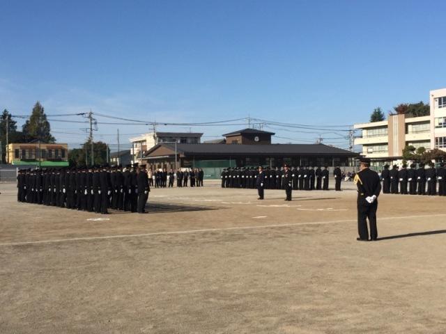 厳粛な雰囲気の中、黒い制服を着た消防団が二手に別れ整列している写真