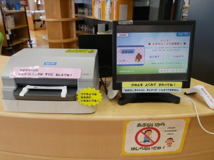 カウンタの上に設置された通帳に記帳する為のプリンターとモニターの写真
