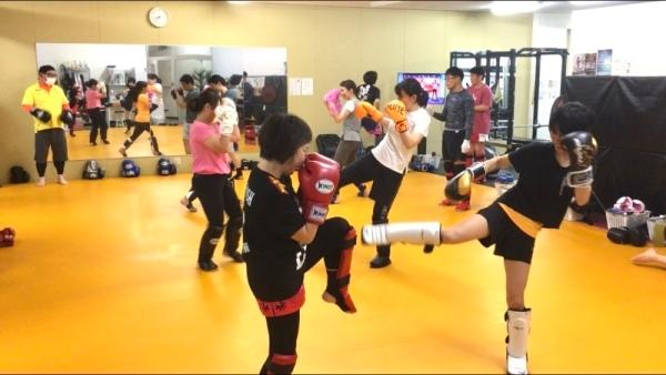 たくさんの女性会員がペアになり、キックボクシングを練習している様子の写真