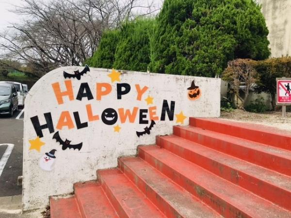 オレンジ色の8段の階段の横壁に「HAPPY HALLOWEEN」の文字とおばけの絵が貼ってある写真
