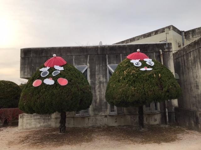 子供公園内にある2本の木がサンタクロース風に飾られている写真