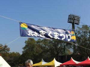 青空の下、「北本きくまつり」と書かれた青い旗が風になびいている写真