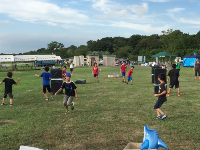 小学生ぐらいの男の子たちが水風船を投げ合う様子の写真