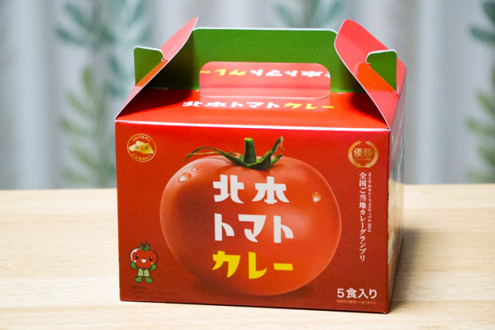 木製のテーブルに置かれた5食入り北本トマトカレーギフトボックスの写真