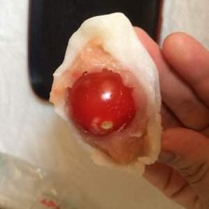 ミニトマトが一粒入っている大福の断面の写真