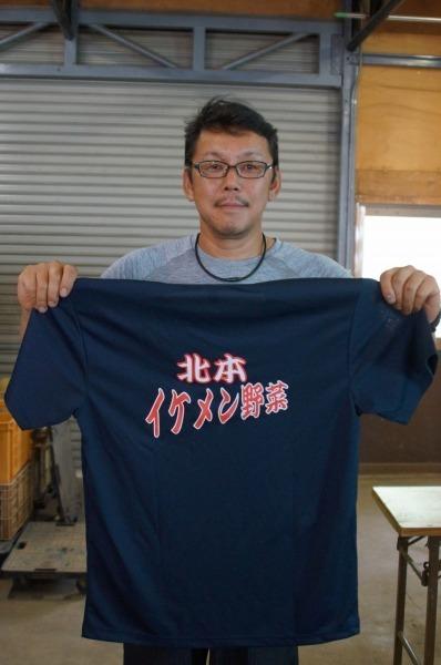 紺色の北本イケメン野菜Tシャツを持っている横山さんの写真