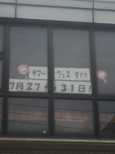2階の窓に文字や数字が書かれた紙が貼り付けられている写真