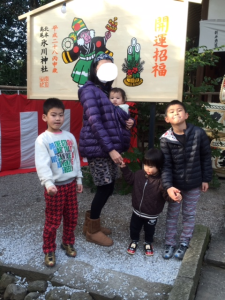 猿が袴を着ている開運招福の看板の前で家族写真を撮っている写真