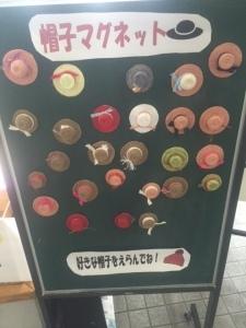 黒板に帽子の形をしたマグネットがたくさん貼ってある写真