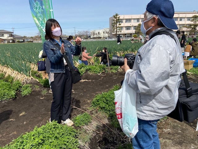 畑に立ち手話で話す市民リポーター岩倉さんと手話サークルの人