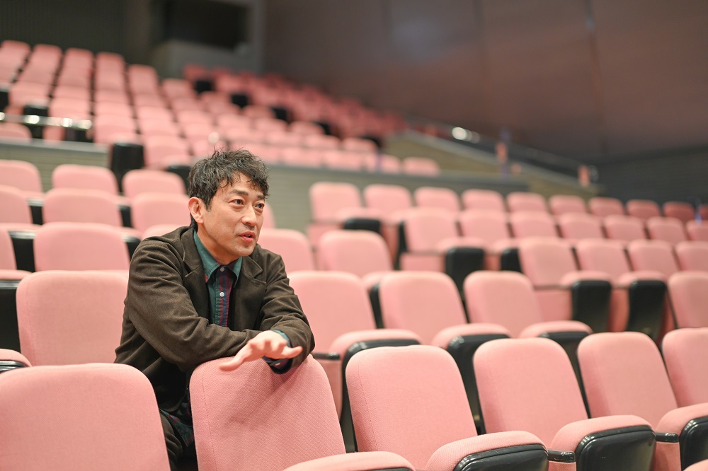 文化センター座席に座る迫田さんの写真3