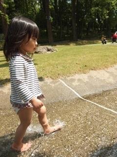 裸足で水遊びを楽しむ女の子の写真