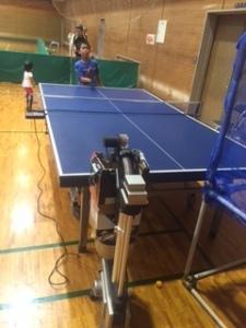 ボールが自動で出てくるマシーンを使って練習をしている男の子の写真