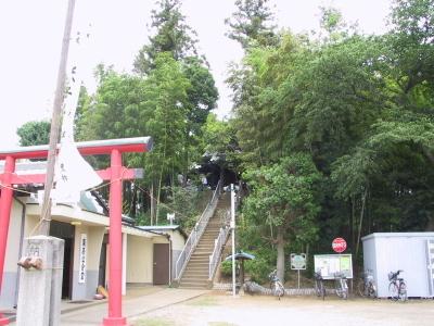 赤い鳥居の奥に木々に囲まれた階段が続いている荒井の富士塚の写真