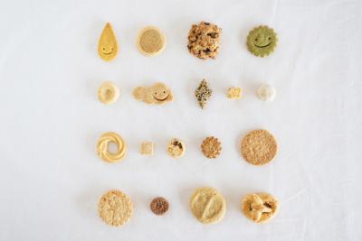丸やスマイルなど様々な形のクッキーが並べられている写真