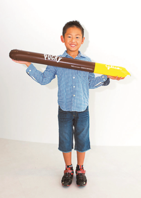 青いシャツを着た男の子がポッキーシューターを両手に持って微笑んでいる写真