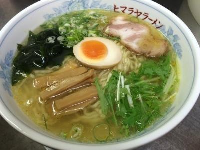 透明なスープに半分にカットされたゆで卵やわかめや野菜が乗っているゆず塩ラーメンの写真