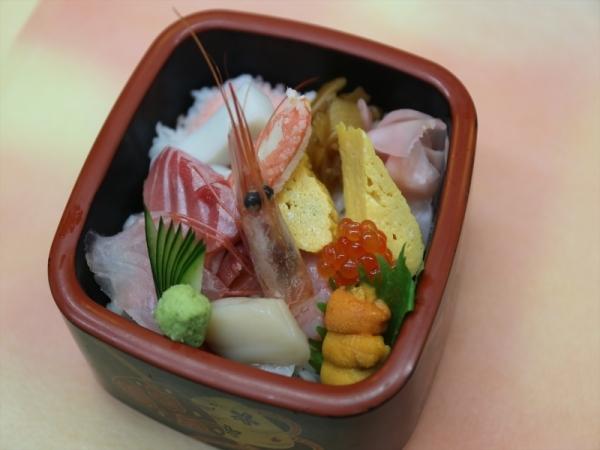 四角い容器にエビやウニ、いくら、などが入ったちらし寿司の写真