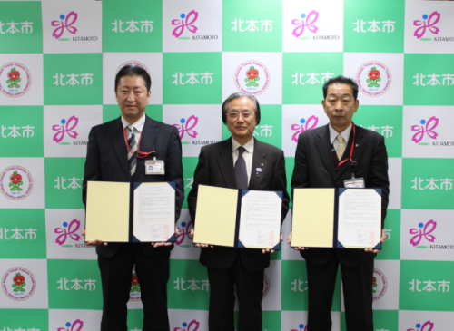 協定書を取り交わした鈴木北本郵便局長（左）、吉田北本駅西口郵便局長（右）と現王園市長（中央）