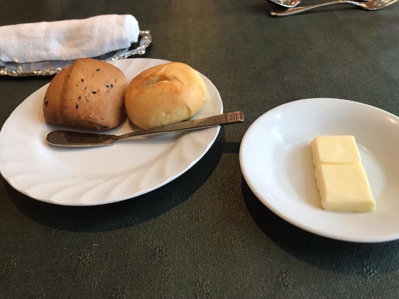 一口サイズのパン２種類が乗った皿ととバターが乗った皿の写真