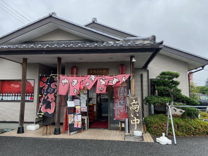 ラーメン屋入口にのぼりと「商い中」の看板が立っている写真