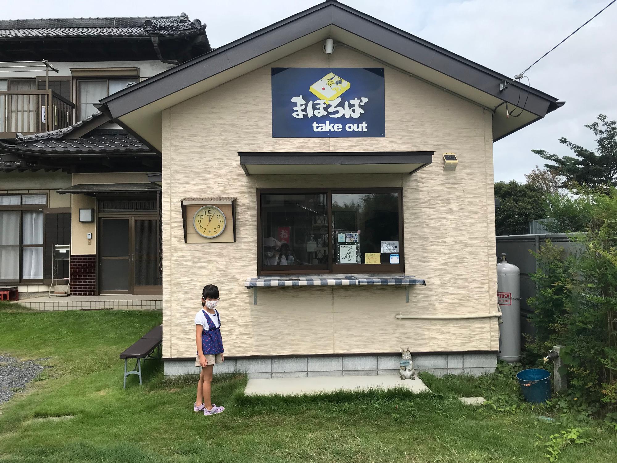 まほろばの店前に女の子が立っている様子