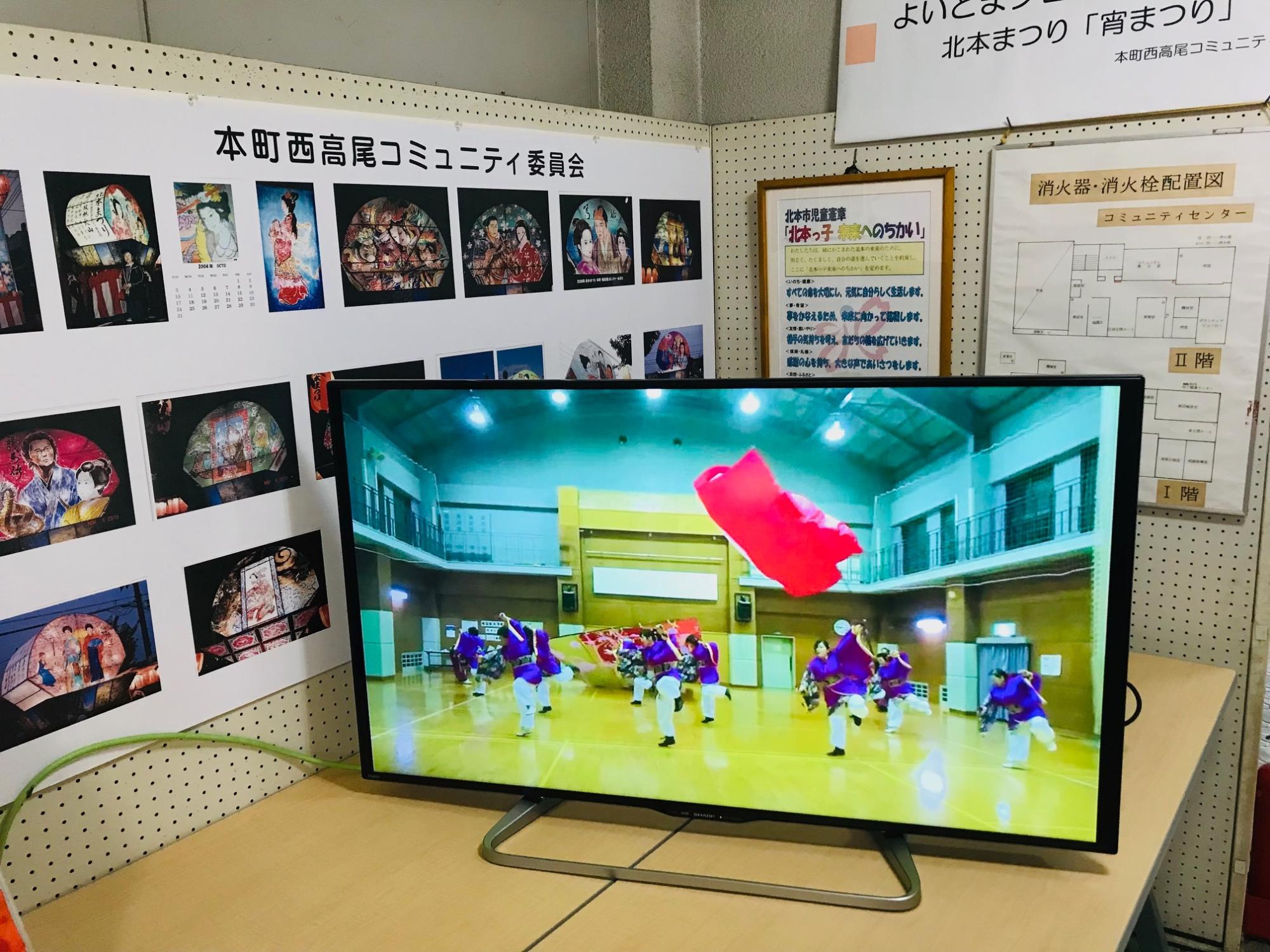 屋内で撮影したパフォーマンスの様子を流しているテレビ画面