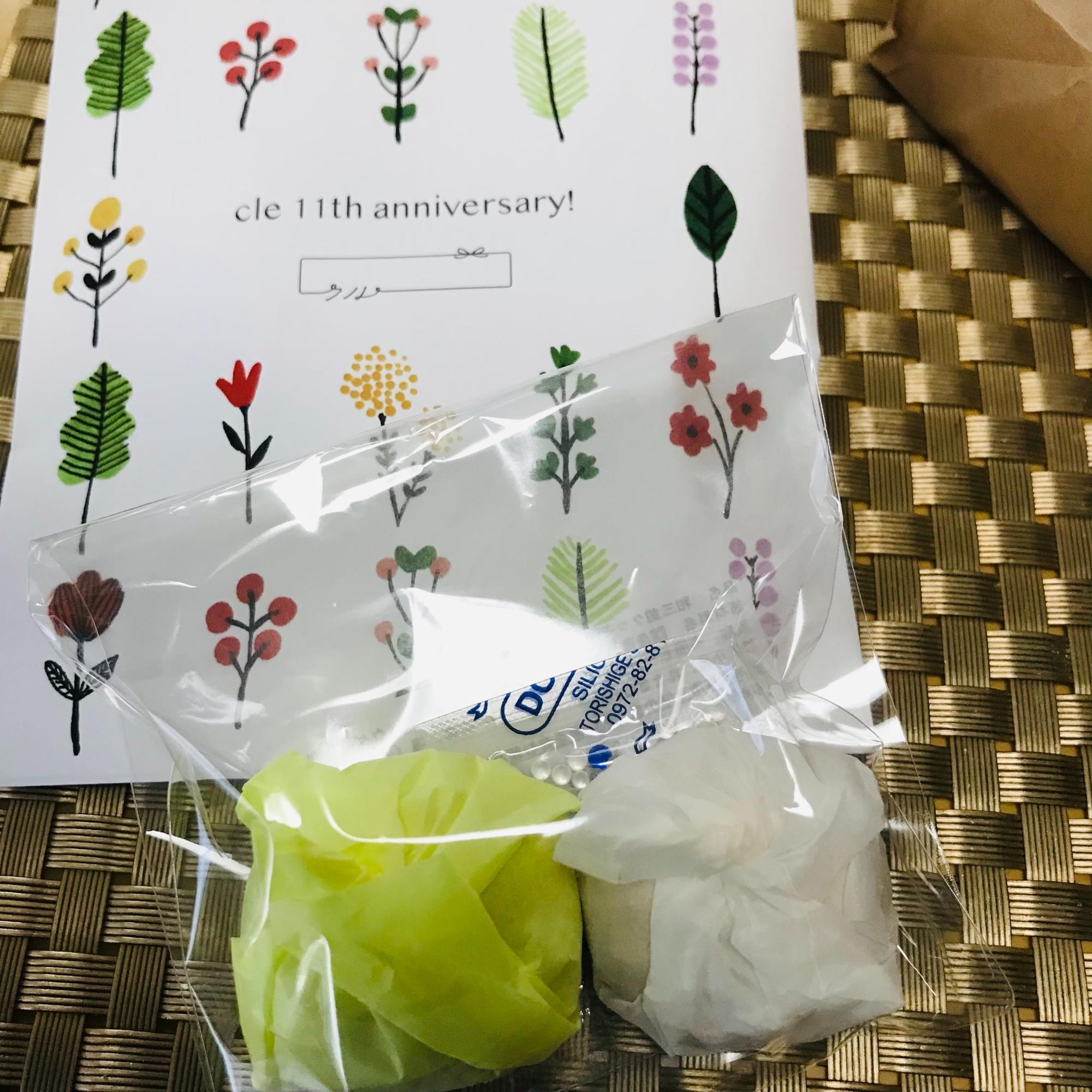 クルの11周年を祝う花柄の袋から取り出した、紙に包まれた2つのクッキー