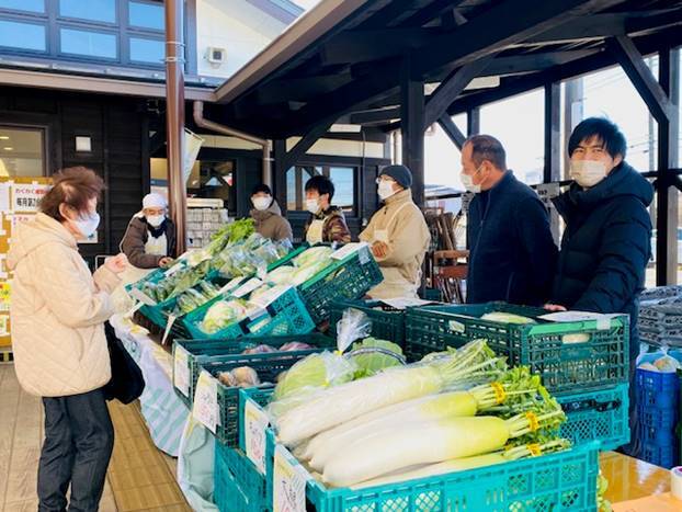 マルシェイベント会場に並べられた野菜を見るお客さんの様子