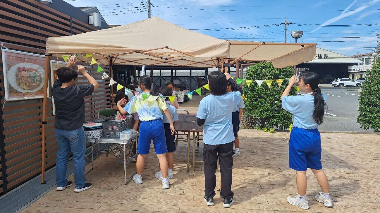 テントに飾りを付けている家庭科部の皆さんの写真