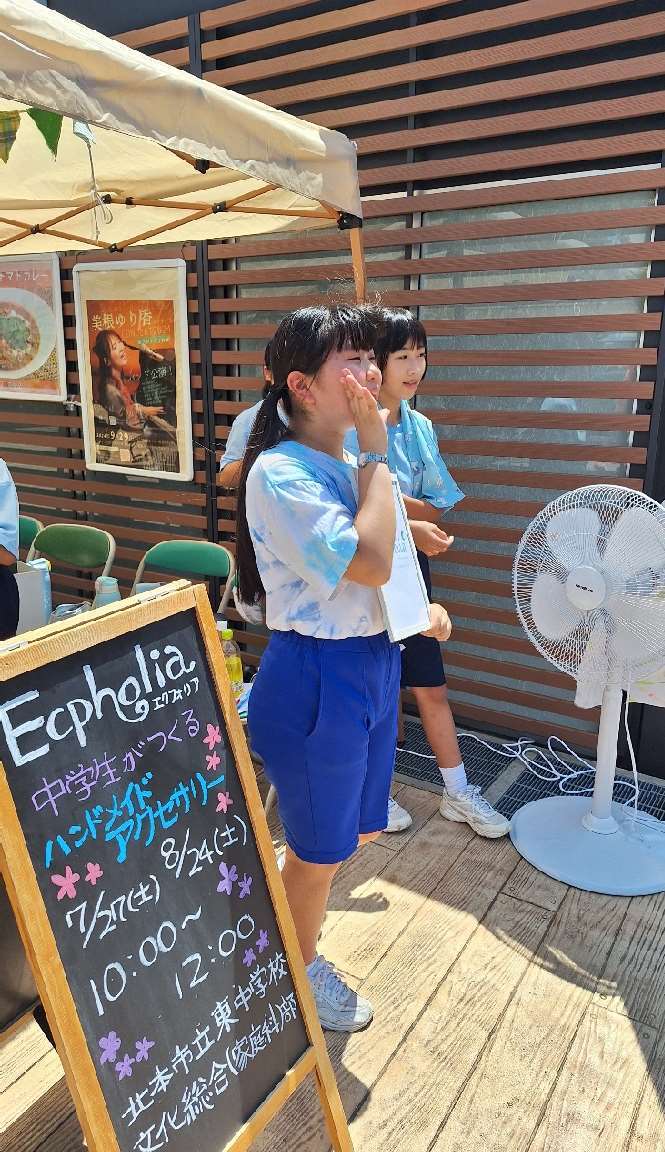 テントの前で呼び込みをする女の子の写真