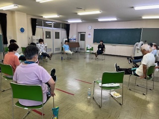 椅子を円形に並べて筋力トレーニングをする参加者の様子