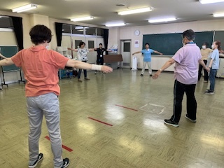 輪になってラジオ体操をする参加者の様子