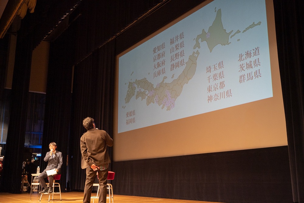 日本地図を眺める迫田さんの写真